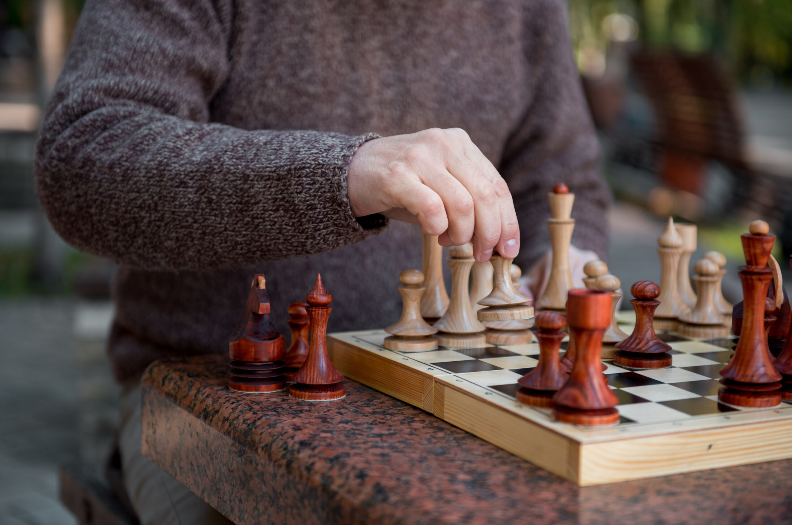 Stock photo of a man playing chess in the park.
