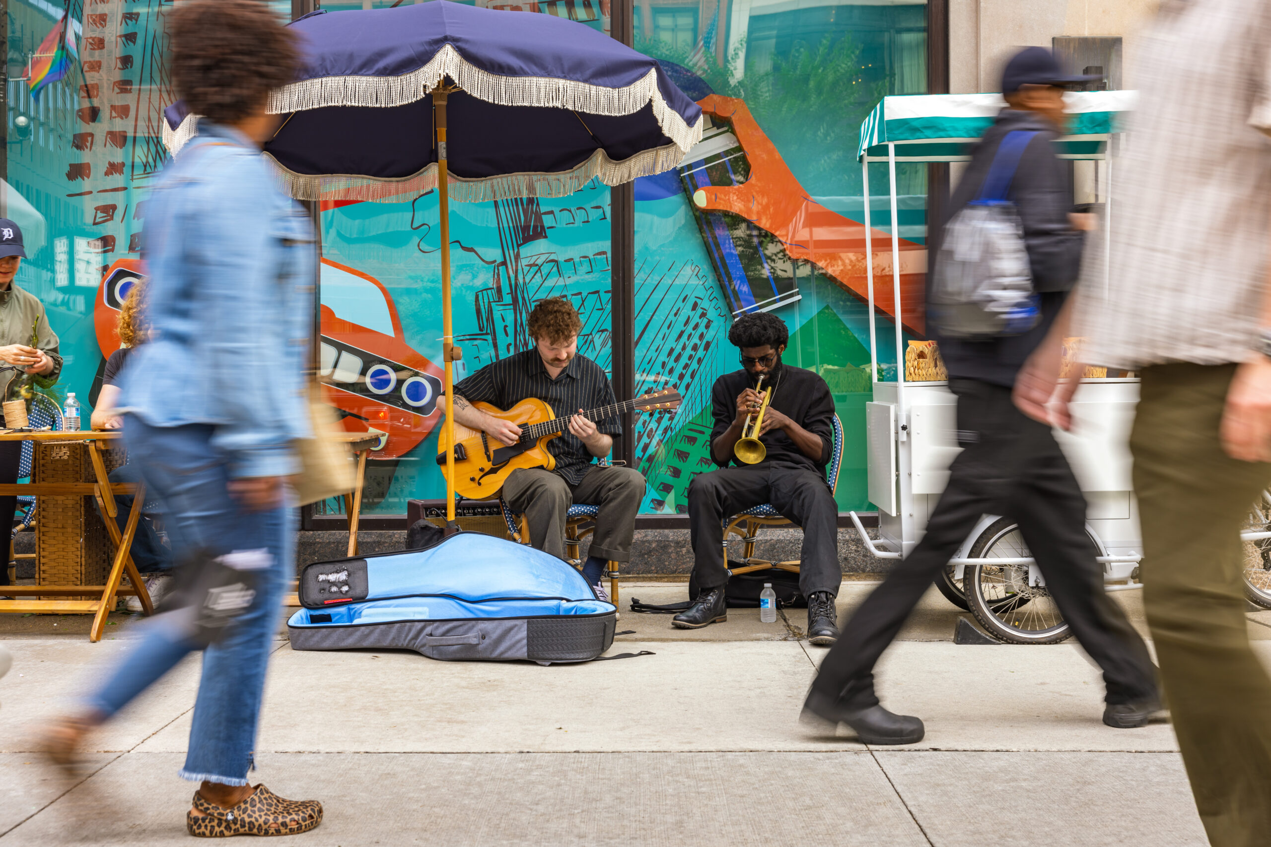 Exterior photo of buskers playing live music on the sidewalk.